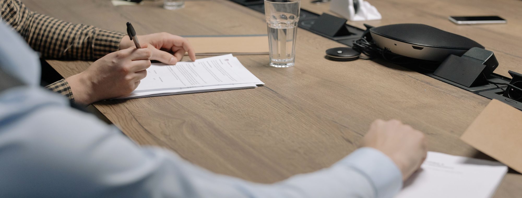 Hands reviewing a contract at a meeting table